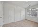 Spare bedroom showing neutral carpet, two closets, and a large window at 2011 Wolftech Ln # 203, Raleigh, NC 27603
