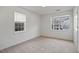 A carpeted bedroom with two windows, offering natural light at 2011 Wolftech Ln # 203, Raleigh, NC 27603