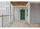 Apartment doorway with light gray siding, dark green door and stained wood floors at 2011 Wolftech Ln # 203, Raleigh, NC 27603