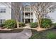 Walkway leading up to an apartment building with green grass and landscaping at 2011 Wolftech Ln # 203, Raleigh, NC 27603