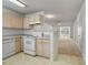 Kitchen showcasing appliances, cream-colored cabinetry and breakfast bar overlooking living area at 2011 Wolftech Ln # 203, Raleigh, NC 27603