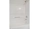 Bright white shower and tub combo with shower head, faucet, towel bar, and built in shelf at 2011 Wolftech Ln # 203, Raleigh, NC 27603