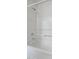 Full tub and shower in bright white with shower head and faucet, as well as shelf and towel bar at 2011 Wolftech Ln # 203, Raleigh, NC 27603