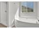 Bright bathroom featuring a walk-in shower, soaking tub, and natural light from the window at 209 Kellerhis Dr, Apex, NC 27502