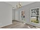 Dining area featuring vinyl floors, gray walls, a chandelier, and natural light from two large windows at 209 Kellerhis Dr, Apex, NC 27502