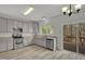 Bright kitchen featuring stainless steel appliances, gray cabinets, and vinyl floors, with a backyard view at 209 Kellerhis Dr, Apex, NC 27502