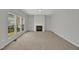 Bright living room features large windows, neutral paint, plush carpet, and a cozy fireplace at 209 Kellerhis Dr, Apex, NC 27502