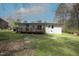 Exterior backyard of a single story white brick house, with a wooden deck, and lush lawn at 221 Lane Of Tristram, Garner, NC 27529