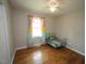 This bright bedroom features hardwood flooring, a ceiling fan, and a large window at 221 Lane Of Tristram, Garner, NC 27529