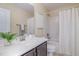 Bright bathroom with white countertops, dark cabinets, a white shower curtain, and a plant at 225 Beckwith Ave, Clayton, NC 27527