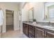 Bathroom with double sinks, granite countertops, dark wood cabinets and an entry to a walk-in closet at 225 Beckwith Ave, Clayton, NC 27527