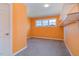 Orange bedroom featuring gray carpet, a window and wall shelving at 225 Beckwith Ave, Clayton, NC 27527