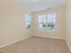 Bedroom with carpeted floors, white trim, and multiple windows with outside views at 225 Beckwith Ave, Clayton, NC 27527