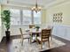 Dining room with a round table, four chairs, wainscoting, decorative mirror art, and natural light at 225 Beckwith Ave, Clayton, NC 27527