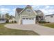 Attached garage with stone accents and a wide driveway, located on a beautifully landscaped lot at 225 Beckwith Ave, Clayton, NC 27527