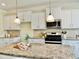 Bright kitchen with white cabinets, granite counters, stainless steel appliances, and a center island perfect for cooking at 225 Beckwith Ave, Clayton, NC 27527