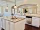 Bright kitchen with white cabinets, granite counters, stainless appliances, and a pass-through to the dining area at 225 Beckwith Ave, Clayton, NC 27527