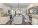 Bright kitchen boasts white cabinets, granite countertops, and stainless steel appliances overlooking the dining area at 225 Beckwith Ave, Clayton, NC 27527