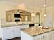 Bright kitchen with white cabinets, granite counters, stainless appliances, and a pass-through to the living room at 225 Beckwith Ave, Clayton, NC 27527