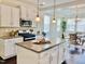 White kitchen with island, granite countertops, stainless appliances and seamless access to a dining area at 225 Beckwith Ave, Clayton, NC 27527
