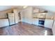 Open kitchen features stainless steel appliances, white cabinets, granite countertops, and wood flooring at 238 N Main St, Wake Forest, NC 27587