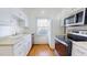 Well-lit kitchen with white cabinetry, stainless steel appliances, and a view from the window at 238 N Main St, Wake Forest, NC 27587