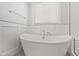 Modern bathroom featuring a soaking tub, stand-up shower, wainscoting, and neutral color palette at 2500 Everett Ave, Raleigh, NC 27607