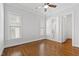 A bedroom with hardwood floors, a ceiling fan, and large windows that bring in natural light at 2500 Everett Ave, Raleigh, NC 27607