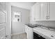 Well-lit laundry room featuring modern washer and dryer, sink, and ample white cabinet storage at 2500 Everett Ave, Raleigh, NC 27607