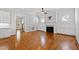 A living room featuring hardwood floors, a ceiling fan, and a fireplace with white built-in cabinets at 2500 Everett Ave, Raleigh, NC 27607