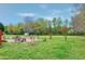 Lush backyard with mature trees, a brick patio, a swing set, and a peaceful setting at 2709 White Rail Dr, Fuquay Varina, NC 27526