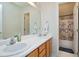 Well-lit bathroom with double sinks, a large mirror, and a separate shower/tub area at 2709 White Rail Dr, Fuquay Varina, NC 27526
