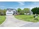 Wide shot of a two-story home with a large front yard and driveway with mature trees at 2709 White Rail Dr, Fuquay Varina, NC 27526