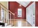 Bright foyer with hardwood floors, staircase with white railings, and a view of the front door at 2709 White Rail Dr, Fuquay Varina, NC 27526