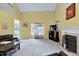 Cozy living room with a fireplace, gray carpet, and large windows for natural light at 2709 White Rail Dr, Fuquay Varina, NC 27526
