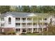 Three-story condo building with white siding, black shutters and balconies surrounded by lush trees at 2800 Trailwood Pines Ln # 301, Raleigh, NC 27603