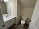 Cozy bathroom featuring a modern vanity and toilet, enhanced by stylish gray wood-look flooring at 2809 Haven Rd, Raleigh, NC 27610