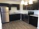 Modern kitchen features stainless steel appliances, stylish dark cabinets, and granite countertops at 2809 Haven Rd, Raleigh, NC 27610