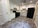 Efficient kitchen features white cabinets, black appliances, and modern gray wood-look flooring at 2809 Haven Rd, Raleigh, NC 27610