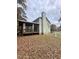 Backyard view showcases a covered porch, white fencing, and a lush, private setting at 306 Smoketree Way, Louisburg, NC 27549