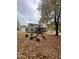 Spacious backyard featuring a covered porch, mature trees, and a unique firepit area with log seating at 306 Smoketree Way, Louisburg, NC 27549