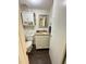 Cozy half bathroom with granite countertop, wooden vanity, and decorative wall cabinet at 306 Smoketree Way, Louisburg, NC 27549