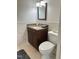 Bathroom with a dark wood vanity, beige tiling, and a grey rug at 306 Smoketree Way, Louisburg, NC 27549