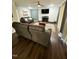 Spacious living room with a brick fireplace, dark couches, and a large tv at 306 Smoketree Way, Louisburg, NC 27549
