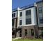 Modern townhome featuring brick facade, sleek windows, and a rooftop terrace at 3102 Kempthorne Rd # 49, Cary, NC 27519