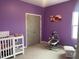Cozy purple Bedroom with a crib, changing table, swing, and a serene atmosphere at 316 Nickleby Way, Wendell, NC 27591