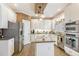 Well-lit kitchen boasts white cabinetry, stainless steel appliances, and granite countertops for cooking enjoyment at 316 Pebble Beach Dr, Mebane, NC 27302