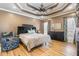 Comfortable main bedroom featuring a tray ceiling, a ceiling fan, and hardwood floors at 316 Pebble Beach Dr, Mebane, NC 27302