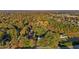 Aerial view of a home surrounded by lush trees in a neighborhood, revealing autumn foliage and a tranquil setting at 347 Cook Rd, Elon, NC 27244