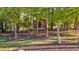 A wooden treehouse in the backyard surrounded by beautiful greenery and trees at 347 Cook Rd, Elon, NC 27244